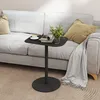 A small black side table with a cup of coffee, books, and a plant on it, placed next to a light gray sofa with cushions and a throw blanket. Anteprima dell’immagine prodotto