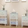 Three wooden chest of drawers with decorative labels on the drawers, placed against a light-colored wall. Náhľad obrázku produktu