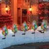 Christmas trees decorated with lights in the snow in front of a house. Anteprima dell’immagine prodotto
