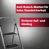 A close-up of a silver step stool with black treads, set against a gradient gray background. Red marketing text overlays are present on the right side of the image. Produktbild-Vorschau