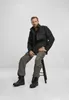 A man is sitting on a stool wearing a jacket and pants. Produktbild-Vorschau