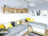 A bedroom with two twin beds, wooden shelves, and decorative items. Produktbild-Vorschau