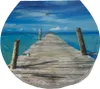 A wooden pier extending into a turquoise ocean under a blue sky with clouds. Produktbild-Vorschau