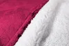 A close-up view of a burgundy and white sherpa-lined blanket or poncho. Náhled obrázku produktu