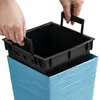 Hands are shown inserting a black plastic planter liner into a blue textured planter pot. Voir les images du produit