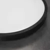 A close-up view of the edge of a round LED ceiling light with a black rim and a white diffuser. Voir les images du produit