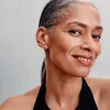 A woman is smiling and looking at the camera, wearing earrings. Produktbild-Vorschau