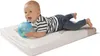 A baby is lying on a changing mat and playing with a blue sensory ball. Produktbild-Vorschau