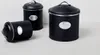 Three black storage containers with silver accents are arranged on a light gray surface against a white background. Produktbild-Vorschau