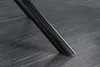 A close-up shot of the black metal leg of a chair resting on a dark, textured floor. Produktbild-Vorschau