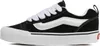 A side view of a black Vans sneaker with white laces and a white sole. Voir les images du produit