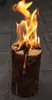 A burning log fire on a paved surface. Produktbild-Vorschau