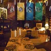 A dimly lit room decorated with Harry Potter-themed banners and hanging LED candles, set up for a dinner party. Produktbild-Vorschau
