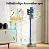 A blue cordless vacuum cleaner is shown standing upright against a wall, with animated green leaves and small yellow flowers swirling around it, suggesting air purification and aromatherapy. Voir les images du produit