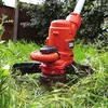 A close-up shot of a string trimmer cutting grass in a garden. Náhľad obrázku produktu