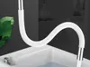 A white flexible faucet extension is shown in a bathroom or kitchen sink. Produktbild-Vorschau