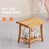 A teak shower bench with toiletries on the lower shelf, with a person holding a shower head in the background. Podgląd zdjęcia produktu
