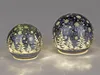 Two decorative LED light spheres with a Christmas tree and snowflake design. Produktbild-Vorschau