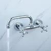 A chrome wall-mounted faucet with two handles is shown with water flowing from the spout against a marble-patterned wall. Produktbild-Vorschau
