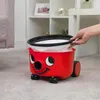 A person's hand is shown inserting a filter into a red Henry vacuum cleaner. Náhled obrázku produktu