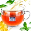 A clear glass mug filled with amber liquid, with mint leaves and splashes of liquid around it. Voir les images du produit