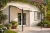 A pavillion is set up on a patio in front of a house, with plants and flowers surrounding it. Produktbild-Vorschau