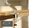 A white monitor stand clamped to a wooden desk. Produktbild-Vorschau