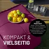 A close-up of a purple beanbag with a bowl of lemons and limes on it, and a tray with drinks in the background. Produktbild-Vorschau