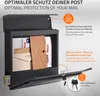 A dark gray mailbox filled with mail, with its front flap open and keys attached to the lock. Produktbild-Vorschau