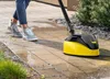 A person is cleaning a tiled patio with a pressure washer attachment. Voir les images du produit