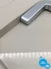 A close-up view of a silver handle on a beige mini-refrigerator. Anteprima dell’immagine prodotto