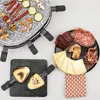 A raclette grill with various food items arranged around it, including skewers, vegetables, cheese, and cured meats. Produktbild-Vorschau