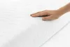 A hand pressing down on a white mattress. Náhľad obrázku produktu