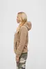 A woman is shown from the side wearing a beige teddy fleece jacket and camouflage pants. Produktbild-Vorschau