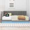 A gray upholstered daybed with a tablet, pillows, and a blanket on it, set against a white wall with a poster. Produktbild-Vorschau
