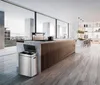 A modern, spacious kitchen with a large island and a view of the city outside. Produktbild-Vorschau