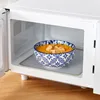A bowl of soup with croutons inside a microwave. Produktbild-Vorschau