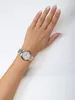 A woman's arm wearing a watch against a white background. Voir les images du produit