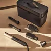 A hair styling set with multiple attachments and a storage case, laid out on a textured surface. Produktbild-Vorschau