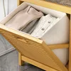 A close-up view of a wooden laundry shelf with fabric baskets containing folded clothes. Produktbild-Vorschau