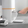 A person's hand is shown inserting a filter into a white and orange vacuum cleaner base station. A portion of the vacuum cleaner and its floor brush attachment are also visible. Náhled obrázku produktu