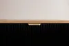 A close-up view of a black cabinet with a wooden top and a gold handle. Náhled obrázku produktu
