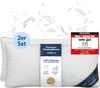 Two white pillows are shown with feathers floating around them. A label on the pillows describes them as premium down pillows, and a test seal is visible on the right. Náhľad obrázku produktu