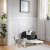 A cat walks past a modern, enclosed litter box with a step in a well-lit room with white paneled walls and a window with white curtains. Anteprima dell’immagine prodotto