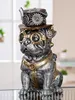 A steampunk-styled pug figurine sits on a reflective surface, with a blurred background of indoor plants and furniture. Anteprima dell’immagine prodotto