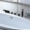 A close-up view of a modern bathtub faucet and controls, with a window and curtains visible in the background. Produktbild-Vorschau