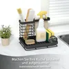 A kitchen cleaning organizer set containing brushes, a spray bottle, and sponges, placed on a countertop next to a sink. Produktbild-Vorschau