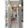 Interior view of a modern walk-in closet with open doors, showing shelves, clothing, and sports equipment. Produktbild-Vorschau