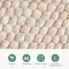 A close-up view of a textured rug with a woven pattern, accompanied by four circular icons with text below them. Produktbild-Vorschau