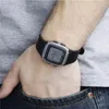 A person's wrist wearing a digital watch, with their hand in their jeans pocket. Náhľad obrázku produktu